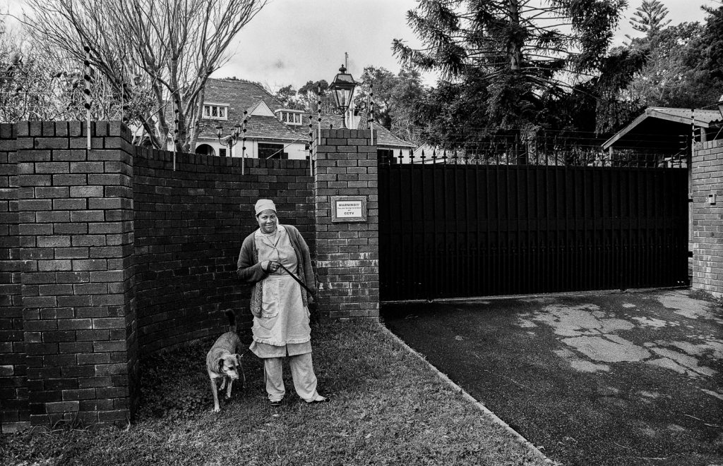 Domestic worker walking the dog outside employer’s mansion, Bishop’s Court, 2009.